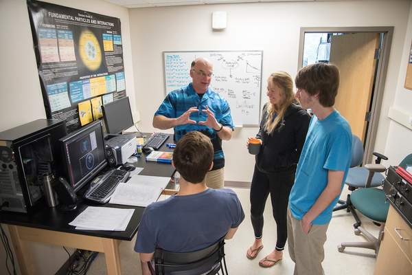 Students listen to a professor during a collaborative research over the summer.