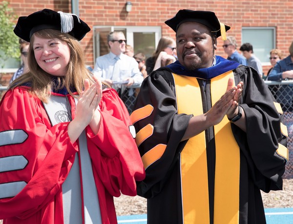 History professors Anna Peterson and Richard Mtisi cheering on graduates at this past year's graduation.